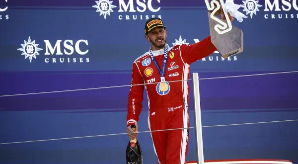 Lewis Hamilton celebra su victoria en el podio, con trofeo y champán. Su edad no se refleja en su energía.