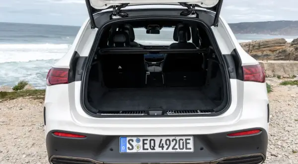 Maletero abierto de un Mercedes EQA blanco, listo para cargar equipaje en un viaje a la costa.
