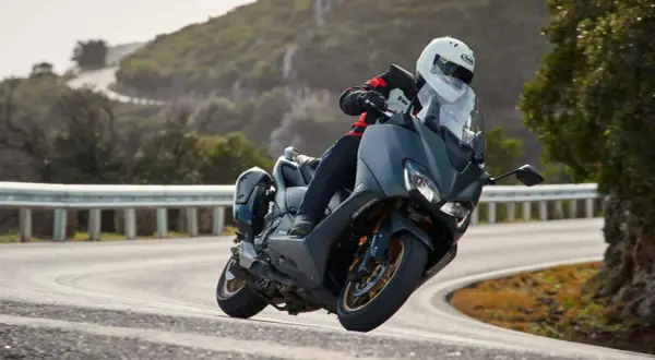 Motociclista en TMAX, disfrutando de la velocidad máxima en una carretera sinuosa.