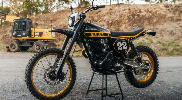 Yamaha XT 500 Dakar, negra y dorada, lista para la aventura. Excavadora CAT al fondo.