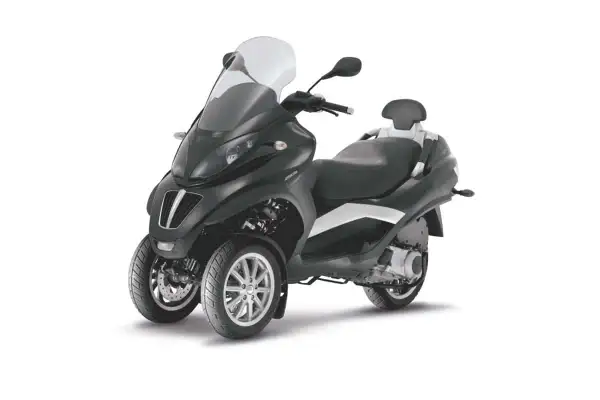 Elegante moto con dos ruedas delanteras, parabrisas alto y asiento doble.