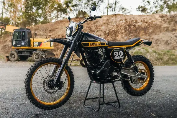 Yamaha XT 500 Dakar, negra y dorada, lista para la aventura. Excavadora CAT al fondo.